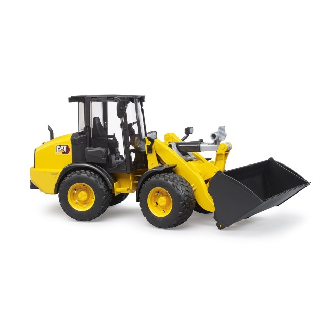 Yellow Caterpillar wheel loader by Bruder on a white background.